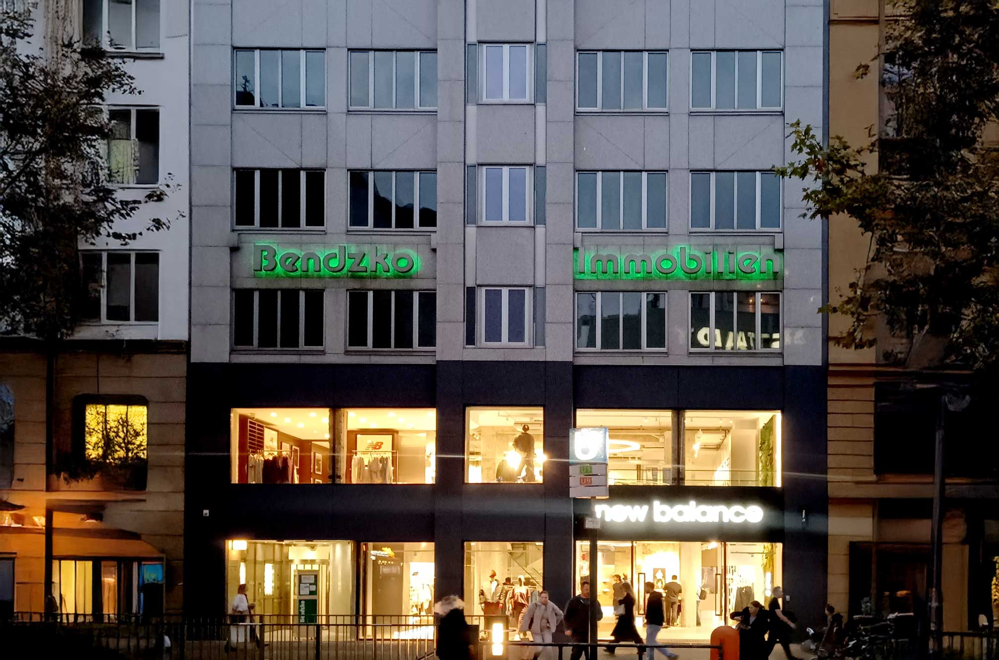 Bendzko Immobilien am Ku-Damm in der Abenddämmerung beleuchtet